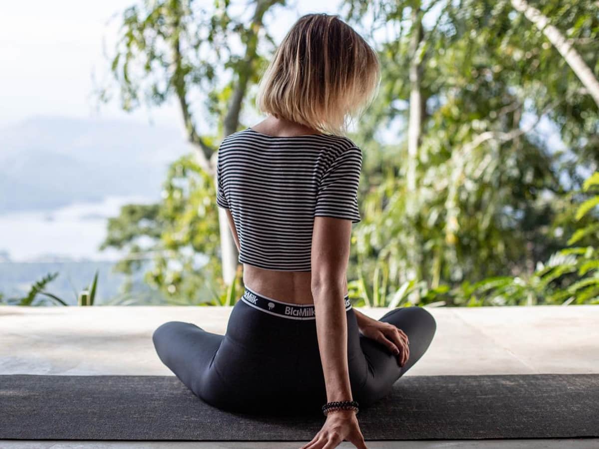 A guest sitting in meditation on the terrace, looking out over the valley