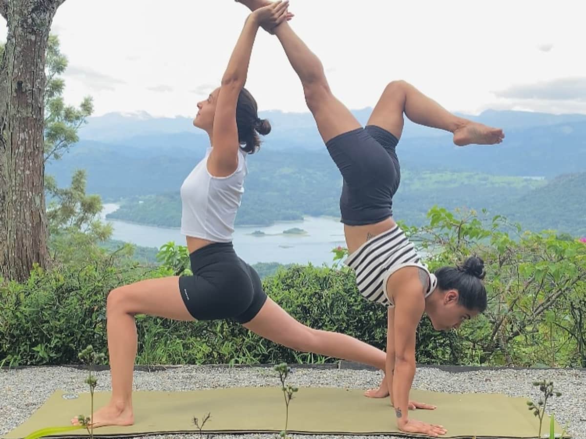 Two practitioners in partner yoga above Victoria Lake